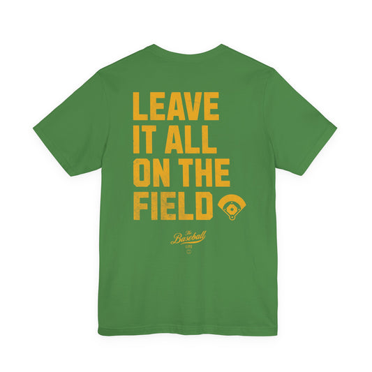 A green t-shirt back with the phrase LEAVE IT ALL ON THE FIELD printed in bold gold letters, with a baseball field graphic.