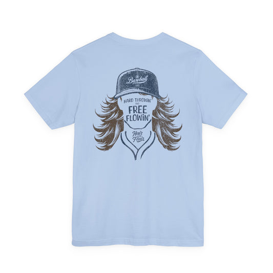 A light blue short-sleeve baseball t-shirt featuring a large graphic print on the back of a baseball player with long brown hair, a baseball cap, with the text: Hard Throwin' and Free Flowin' and Hair with Flair.