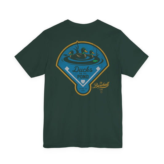 The back of a forest green baseball t-shirt featuring a "Ducks on the Pond" graphic with The Baseball Life logo.