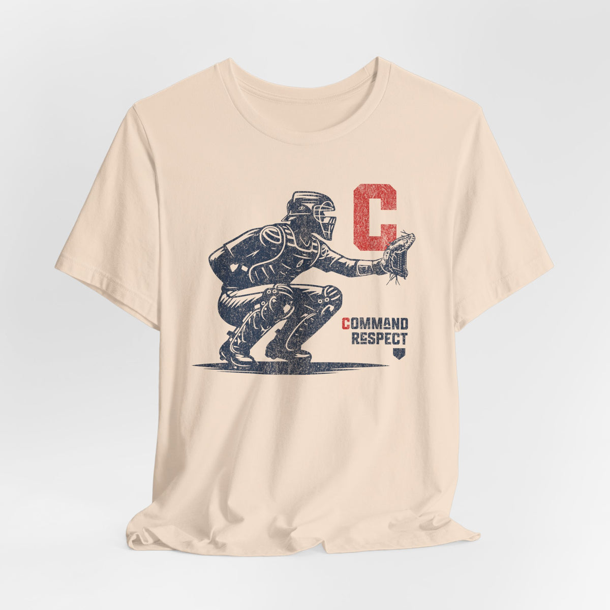 A soft cream t-shirt featuring a baseball catcher and the words COMMAND RESPECT in navy, and a red letter C.