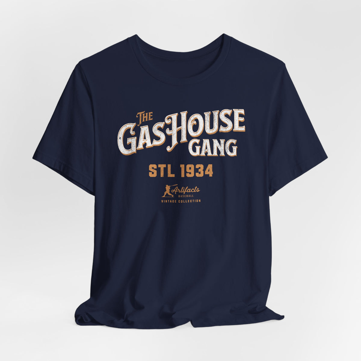A navy blue short-sleeve t-shirt with a vintage-style graphic print reading 'The Gas House Gang STL 1934' and a small 'Artifacts Collection' logo.