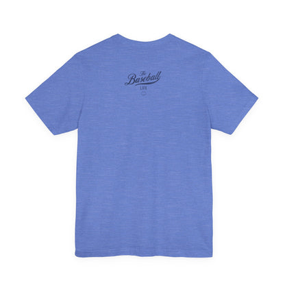 A heather blue t-shirt with a distressed navy blue The Baseball Life logo centered on the upper back.