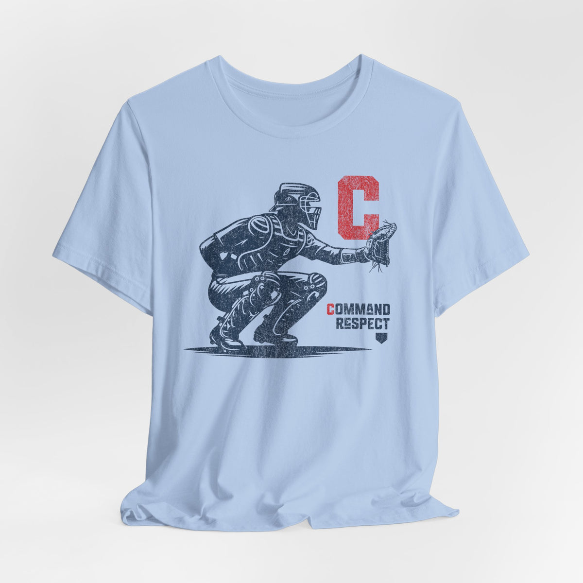 A baby blue t-shirt featuring a baseball catcher and the words COMMAND RESPECT in navy, and a red letter C.