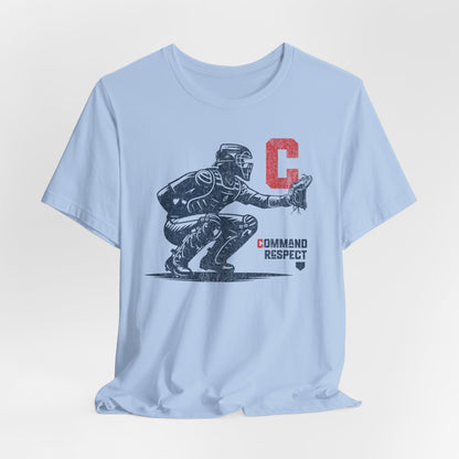 A baby blue t-shirt featuring a baseball catcher and the words COMMAND RESPECT in navy, and a red letter C.