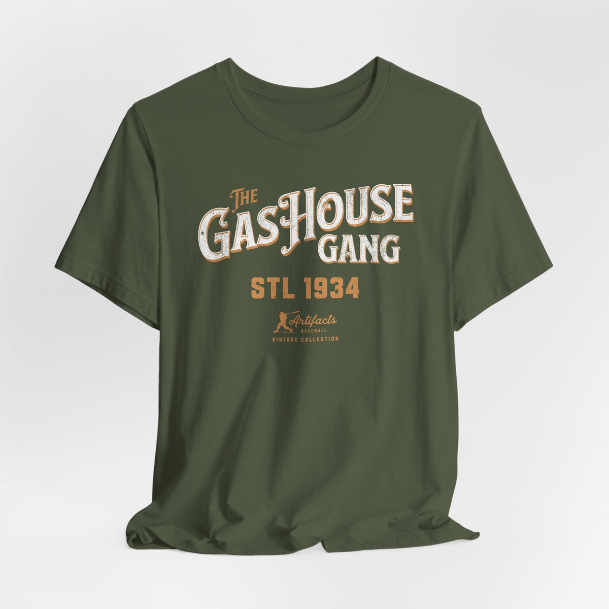 A military green short-sleeve t-shirt with a vintage-style graphic print reading 'The Gas House Gang STL 1934' and a small 'Artifacts Collection' logo.