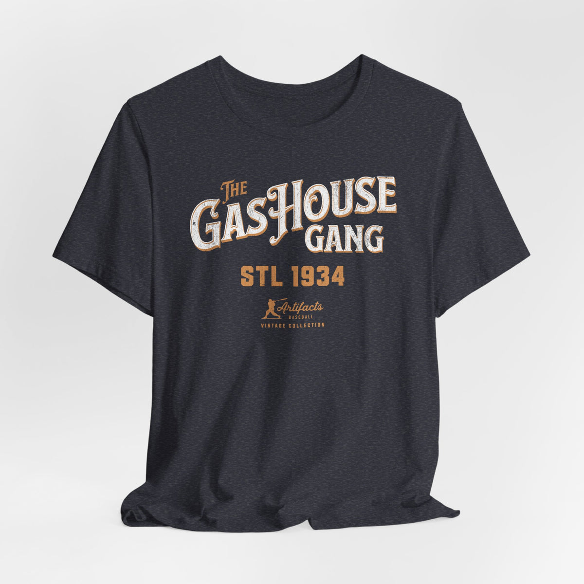 A heather navy short-sleeve t-shirt with a vintage-style graphic print reading 'The Gas House Gang STL 1934' and a small 'Artifacts Collection' logo.